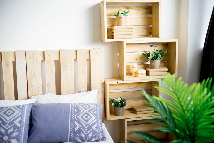 des caisses en bois superposées forme une table de chevet dans la chambre à coucher