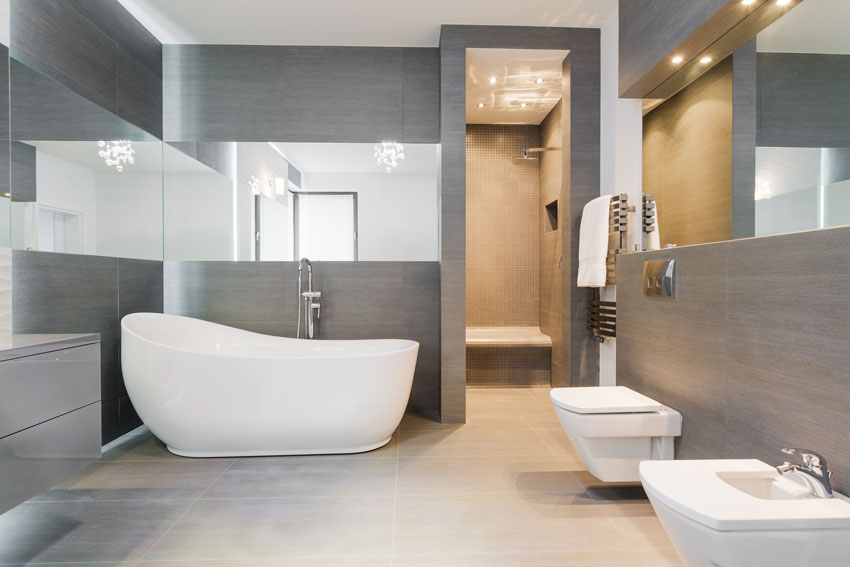 Salle de bain avec carrelage gris, sanitaire blanc, idéal pour une salle de bain de style moderne.
