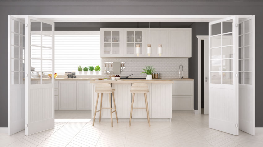 Belle cuisine ouverte blanche et bois avec grandes portes coulissantes.