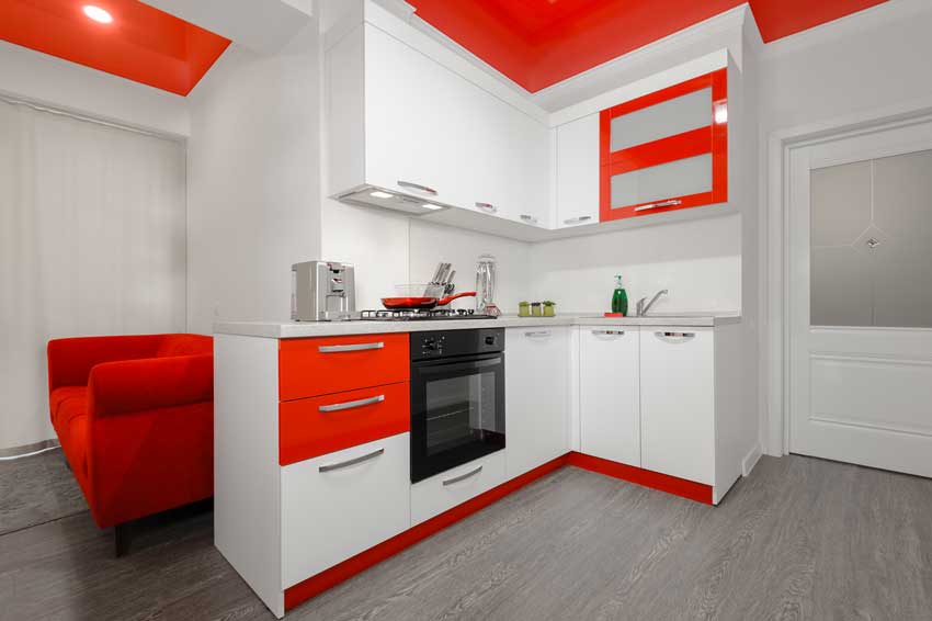 Cuisine blanche avec plafond de couleur rouge.