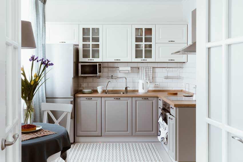 Une cuisine grise et blanche avec plan de travail en bois, idéal pour un style rustique.
