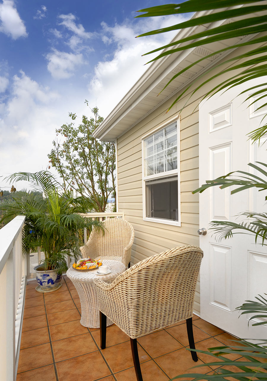 Balcon avec salon extérieur en rotin.