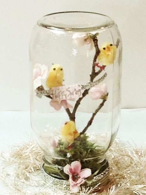 Barattolo di vetro con rami fioriti, ideale per una decorazione di pasqua fai da te.