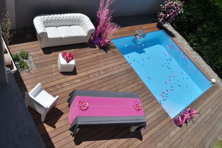 Piscine semi enterrée installée sur une petite terrasse.