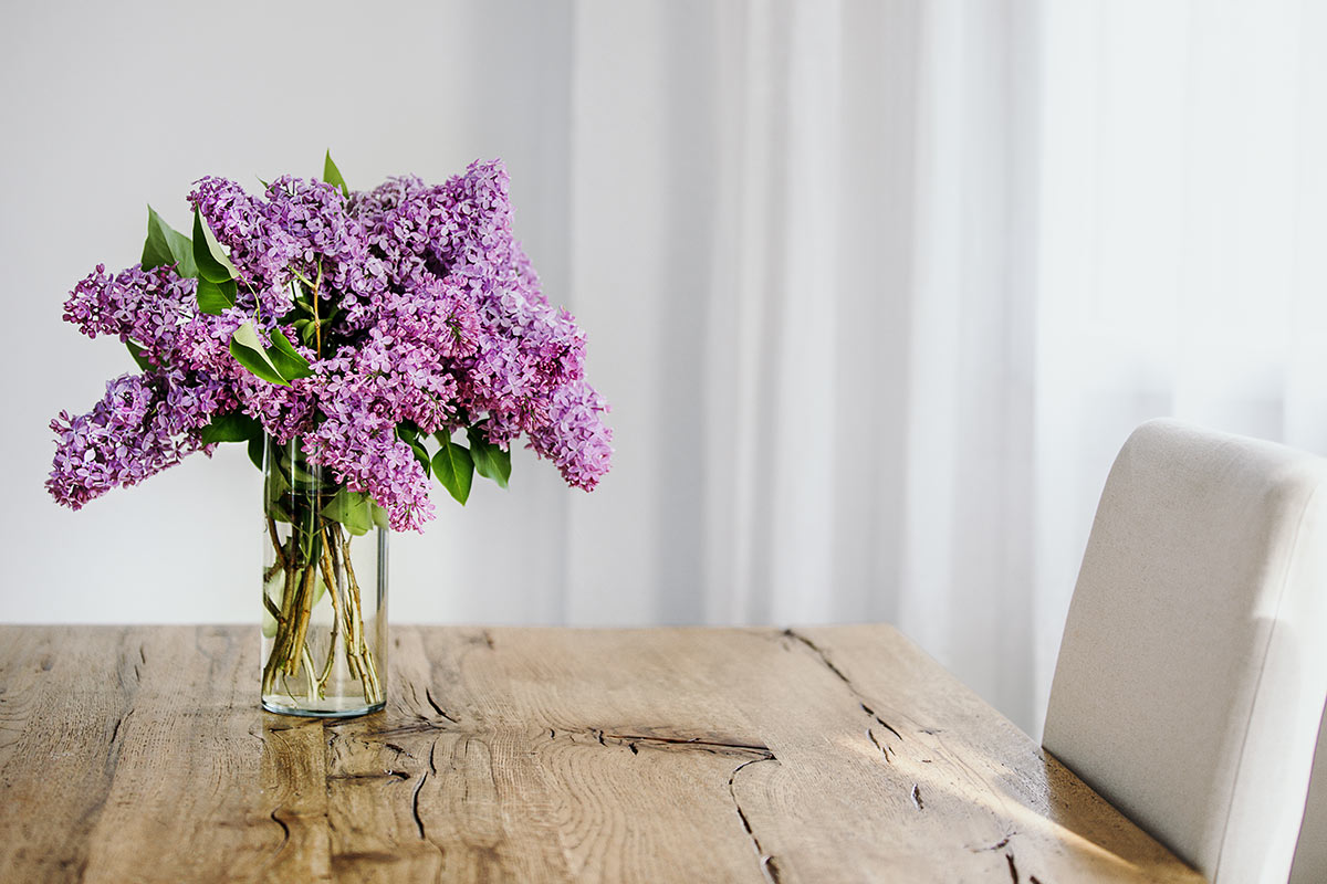 Vase de Lilas sur table en bois.