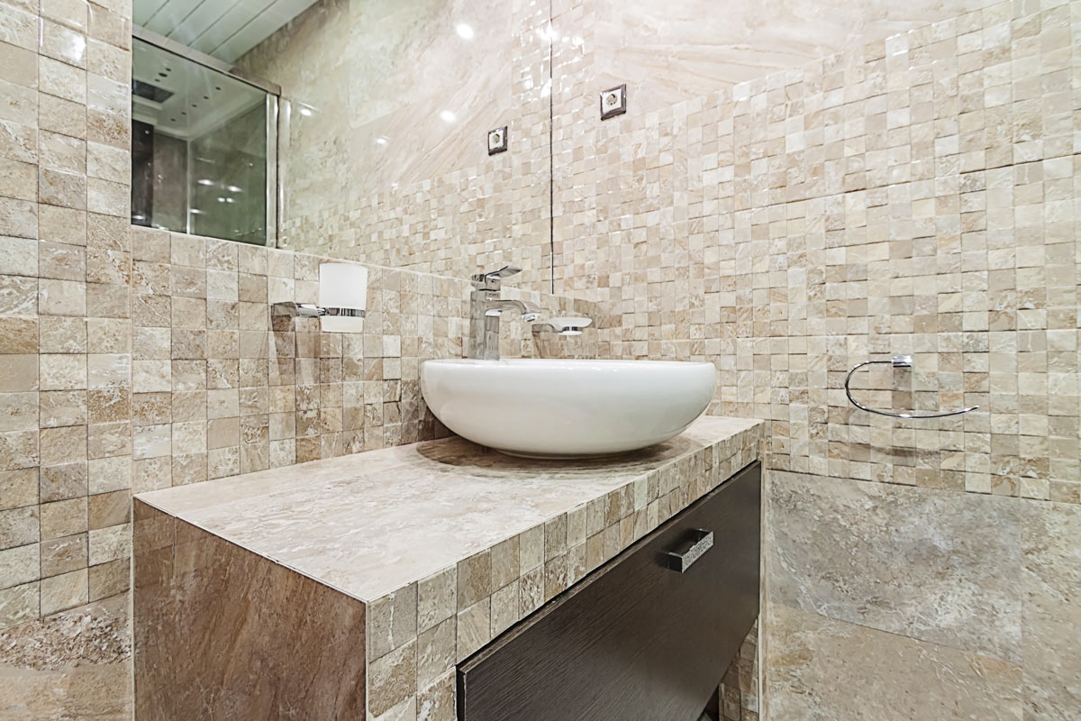 Salle de bain recouverte de mosaïque de pierre.