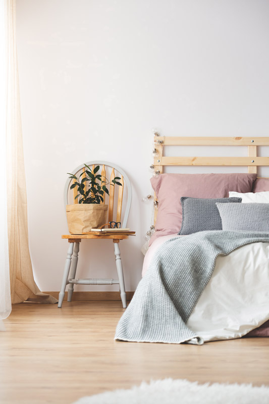 Table de chevet bricolée dans la chambre à coucher avec une chaise de style provençal.