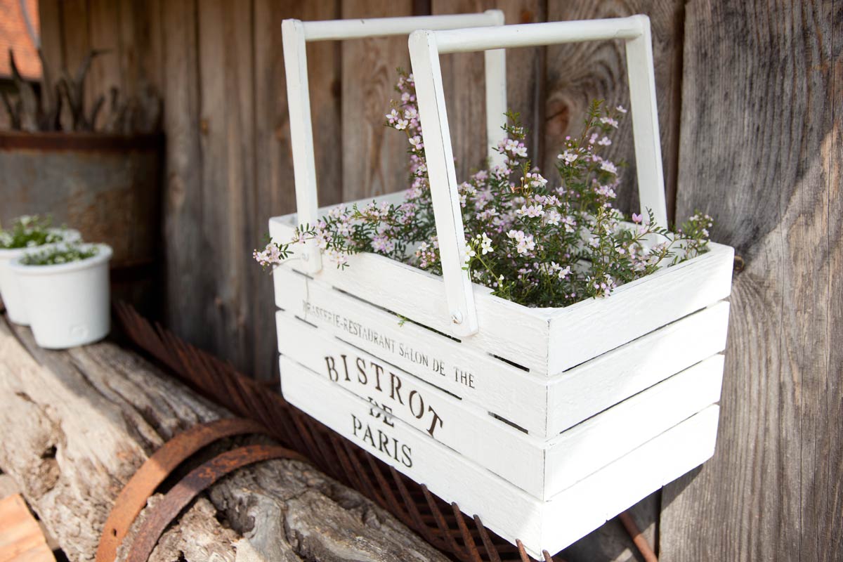 Porte-fleurs vintage avec une caisse en bois.