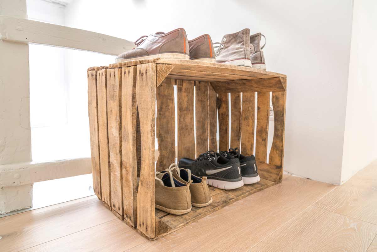 chaussures rangées dans une cagette en bois.