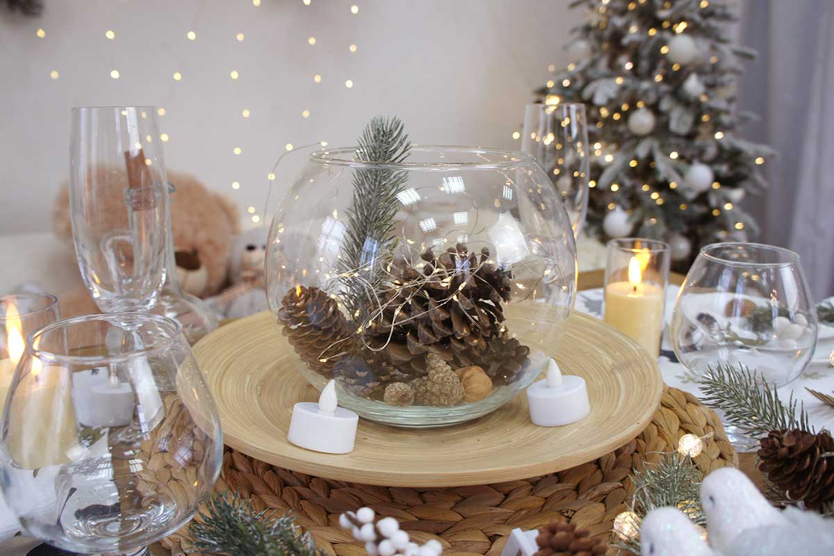 Pommes de pin dans vase rond avec des lumières LED pour Noël.