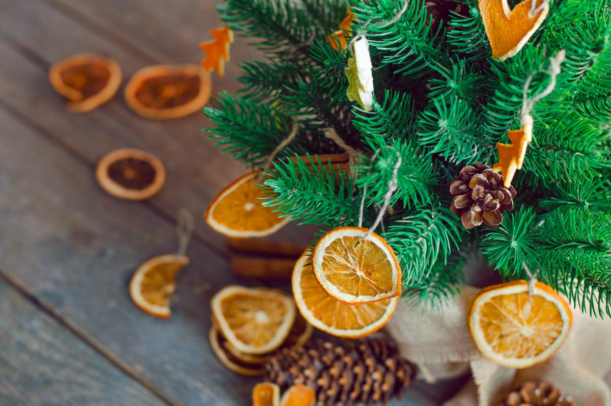 sapin décoré avec pommes de pin et oranges